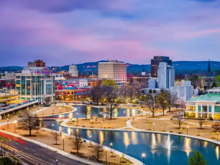 City skyline at dusk with a river, fountains, and illuminated buildings. water damage restoration in Huntsville AL